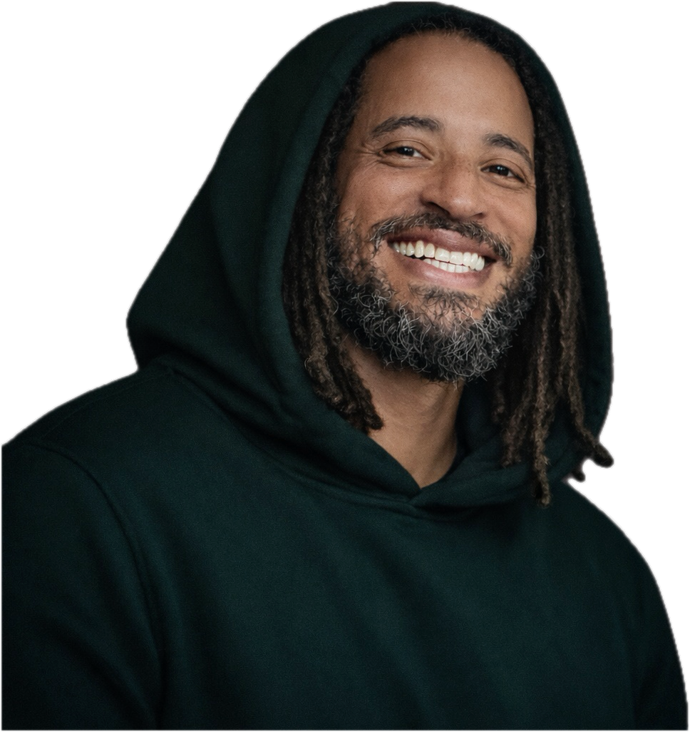 Portrait of Junior Williams smiling in a green hoodie.